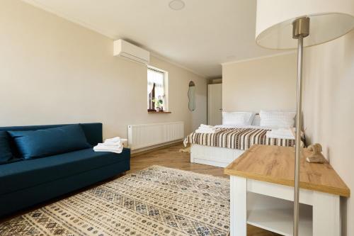 a living room with a blue couch and a bed at OneLife Retreat 