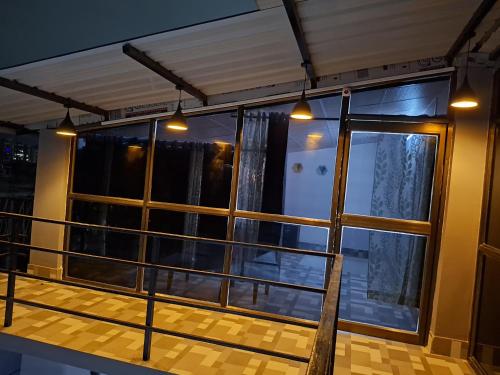 a room with a balcony with windows and lights at Tulip - Duplex on the Terrace in Guwahati