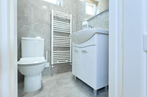 a white bathroom with a toilet and a sink at OneLife Retreat 