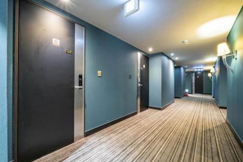 a hallway of an office with blue walls at Benikea Hotel Bizinn in Wonju