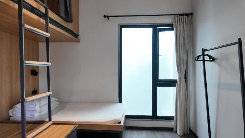 a bedroom with a bunk bed and a window at WeLight Hotel in Beijing