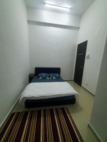 a bed in a small room with a rug at Homestay Pohon Rendang in Balik Pulau