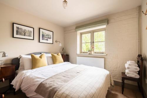 a bedroom with a large white bed with yellow pillows at Pet Friendly Manor House Hop Kiln in Ledbury