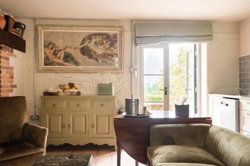 a living room with a couch and a table at Pet Friendly Manor House Hop Kiln in Ledbury