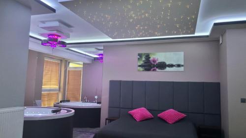 a bathroom with two sinks and a bed with pink pillows at APARTAMENT LUX Bulwary Chrobrego Gniezno in Gniezno