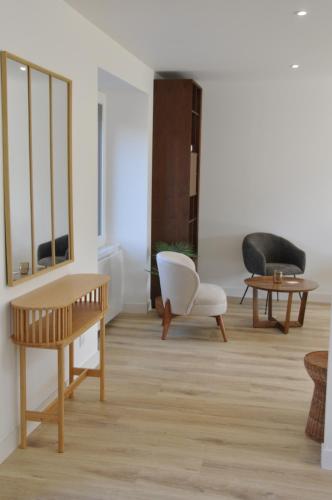 a living room with a table and a chair at 285 - gite de la rue du Chateau Aizenay in Aizenay
