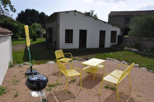 a patio with a table and chairs and a grill at 285 - gite de la rue du Chateau Aizenay in Aizenay