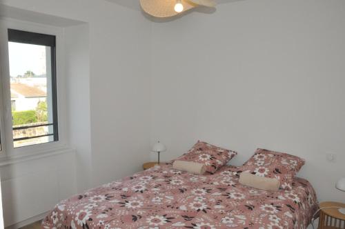 a bedroom with a bed with two pillows and a window at 285 - gite de la rue du Chateau Aizenay in Aizenay
