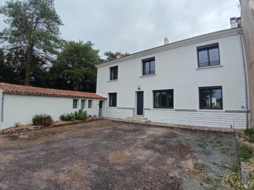 a white house with a parking lot in front of it at 285 - gite de la rue du Chateau Aizenay in Aizenay