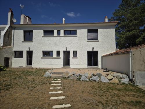 a white house with a stone pathway in front of it at 285 - gite de la rue du Chateau Aizenay in Aizenay