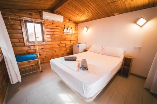 a bedroom with a large white bed in a wooden cabin at Tres Estrellas Mediterráneo in Xilxes