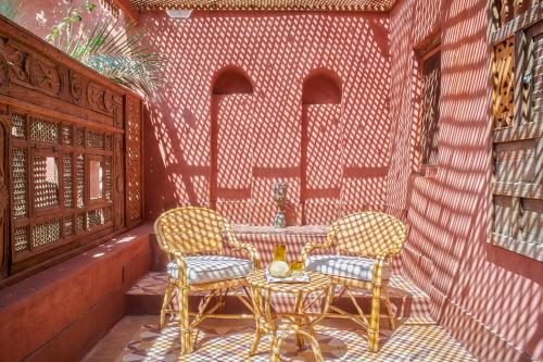 a patio with two chairs and a table at Al Moudira Hotel in Luxor