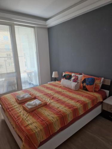 a bedroom with a large bed with two towels on it at Bloom Apartments B in Skopje
