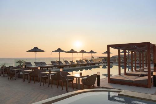 a resort with a pool and tables and chairs at Irida Hotel Agia Pelagia in Agia Pelagia