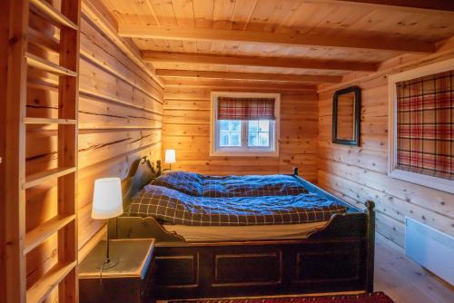 ein Schlafzimmer mit einem Bett in einer Blockhütte in der Unterkunft Trysilfjellet Nord 901 in Trysil