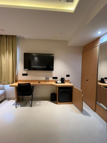 a room with a desk with a television on the wall at Nirvana Nest in Lucknow