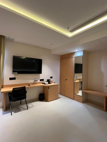 a room with a desk and a television on the wall at Nirvana Nest in Lucknow