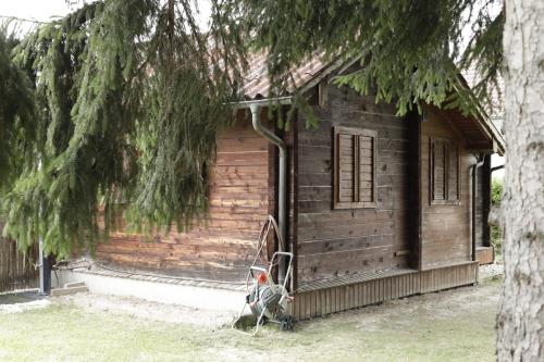 a wooden cabin with a tree in front of it at Gemütliche Blockhütte mit großem Garten in Ried im Innkreis