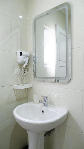 a white bathroom with a sink and a mirror at Diyar Villas Puncak M6/14 in Puncak