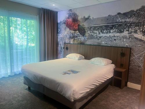a bed in a hotel room with a painting on the wall at Fletcher Hotel Restaurant Doorwerth - Arnhem in Doorwerth