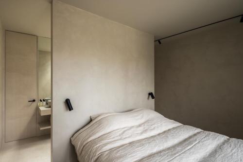 a white bedroom with a bed and a sink at Tranquil Designer Stay with Infinity Pool in Merchtem
