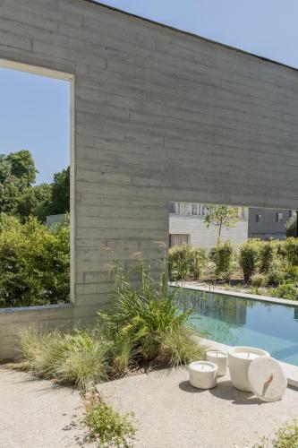 a building with a swimming pool next to a house at Tranquil Designer Stay with Infinity Pool in Merchtem