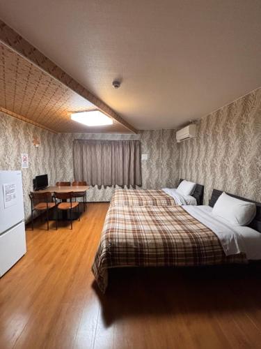a bedroom with a bed and a desk in it at BEPPU HOSTEL U&T in Beppu