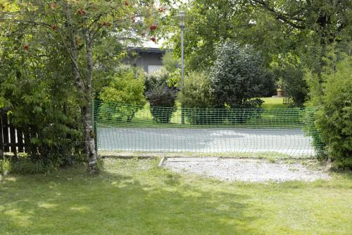 a park with a fence and a bench in the grass at Gemütliche Blockhütte mit großem Garten in Ried im Innkreis