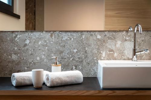 a bathroom with a sink and a bath tub at Knöspele - Brennerei & Genuss-Apartments in Brixen