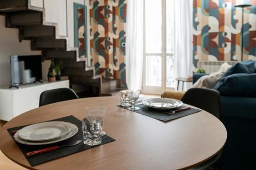 a dining room table with plates and glasses on it at Regina 144 by RD Domus in Turin