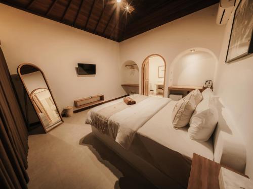 a bedroom with a large white bed in a room at Hiraya Uluwatu in Uluwatu
