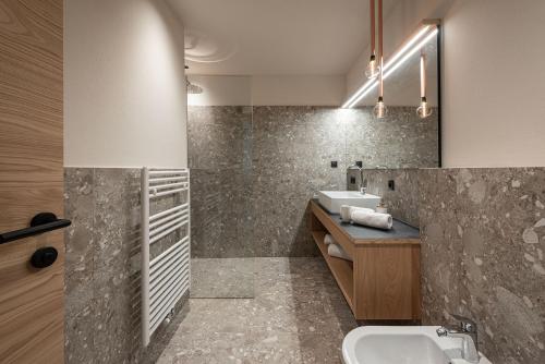 a bathroom with a sink and a mirror at Knöspele - Brennerei & Genuss-Apartments in Brixen