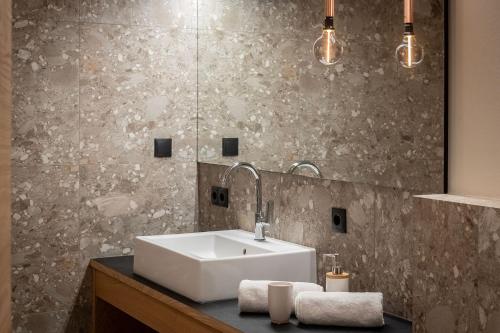 a bathroom with a sink and a mirror at Knöspele - Brennerei & Genuss-Apartments in Brixen