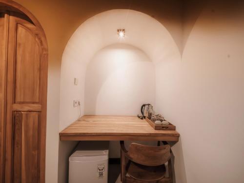 a hallway with a wooden table and a toilet at Hiraya Uluwatu in Uluwatu