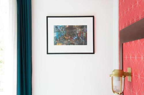 a picture frame on a wall with a picture of a city at Hotel The Playce by Happyculture in Paris