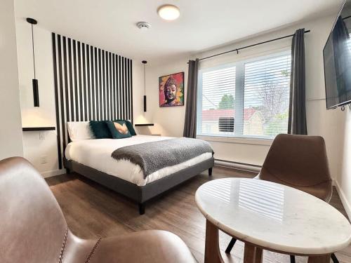 a bedroom with a bed and a table and chairs at Levis Downtown New Studio #3 AC, WiFi and 2 Parking spaces in Lévis
