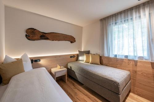 a hotel room with a bed and a window at Knöspele - Brennerei & Genuss-Apartments in Brixen