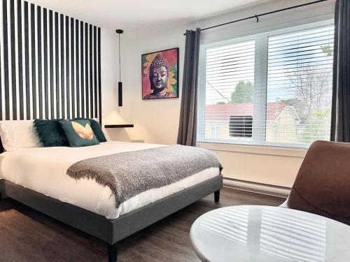 a bedroom with a bed and a table and a window at Levis Downtown New Studio #3 AC, WiFi and 2 Parking spaces in Lévis