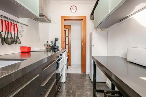 a kitchen with stainless steel countertops and a refrigerator at Apartaments Portbou Costa Brava in Portbou