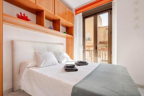 a bedroom with a white bed with two towels on it at Apartaments Portbou Costa Brava in Portbou