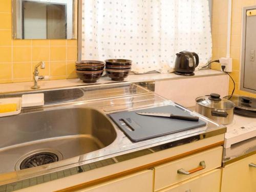 a kitchen sink with a laptop on top of it at Sunflower Hotel 703, Osaka, Namba & Shinsaibashi in Osaka