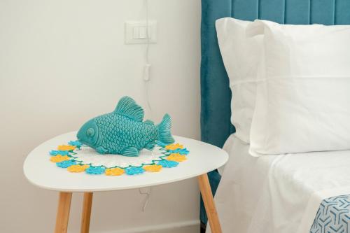 a toy fish on a table next to a bed at Micenei Homes in Otranto