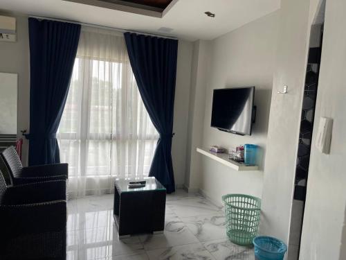 a living room with a window with a chair and a tv at MKB Homestay - 2 X Queen Bed Studio Room with View and Free Parking in Klang