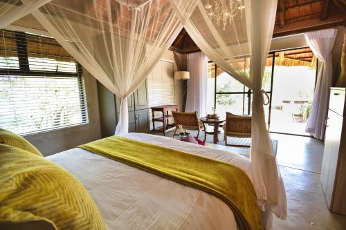 a bedroom with a large bed with a canopy at Mohlabetsi Safari Lodge in Hoedspruit