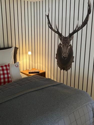 a bedroom with a deer head on the wall at Schittlerhaus in Oberstdorf