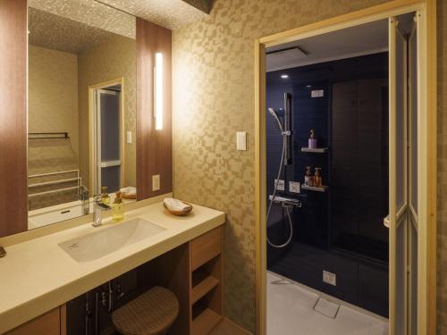 a bathroom with a sink and a shower at Isaribinoyado Seaside Kancho in Wakayama
