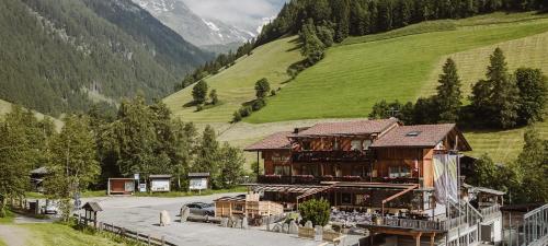 a large wooden building in a valley with a mountain at Die Sportbar in Rio Bianco