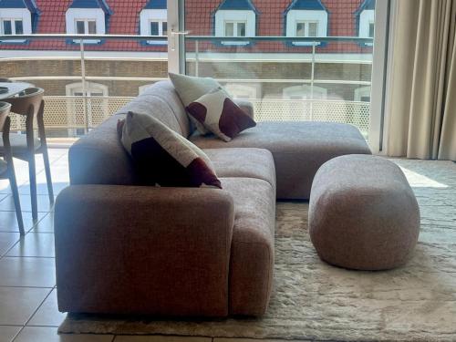 a living room with two couches and a large window at Beachside Family Apartment Windstar 402 in Oostduinkerke