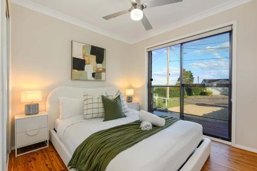 a bedroom with two beds and a large window at Stunning 4BR Home with Pool & Water Views in Koolewong