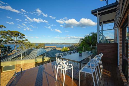 a patio with a table and chairs on a balcony at Stunning 4BR Home with Pool & Water Views in Koolewong